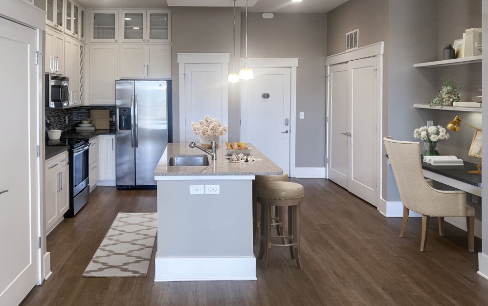 Image of the B1 kitchen at Palladian Place with vinyl plank floors, floating kitchen island, and stainless steel appliances