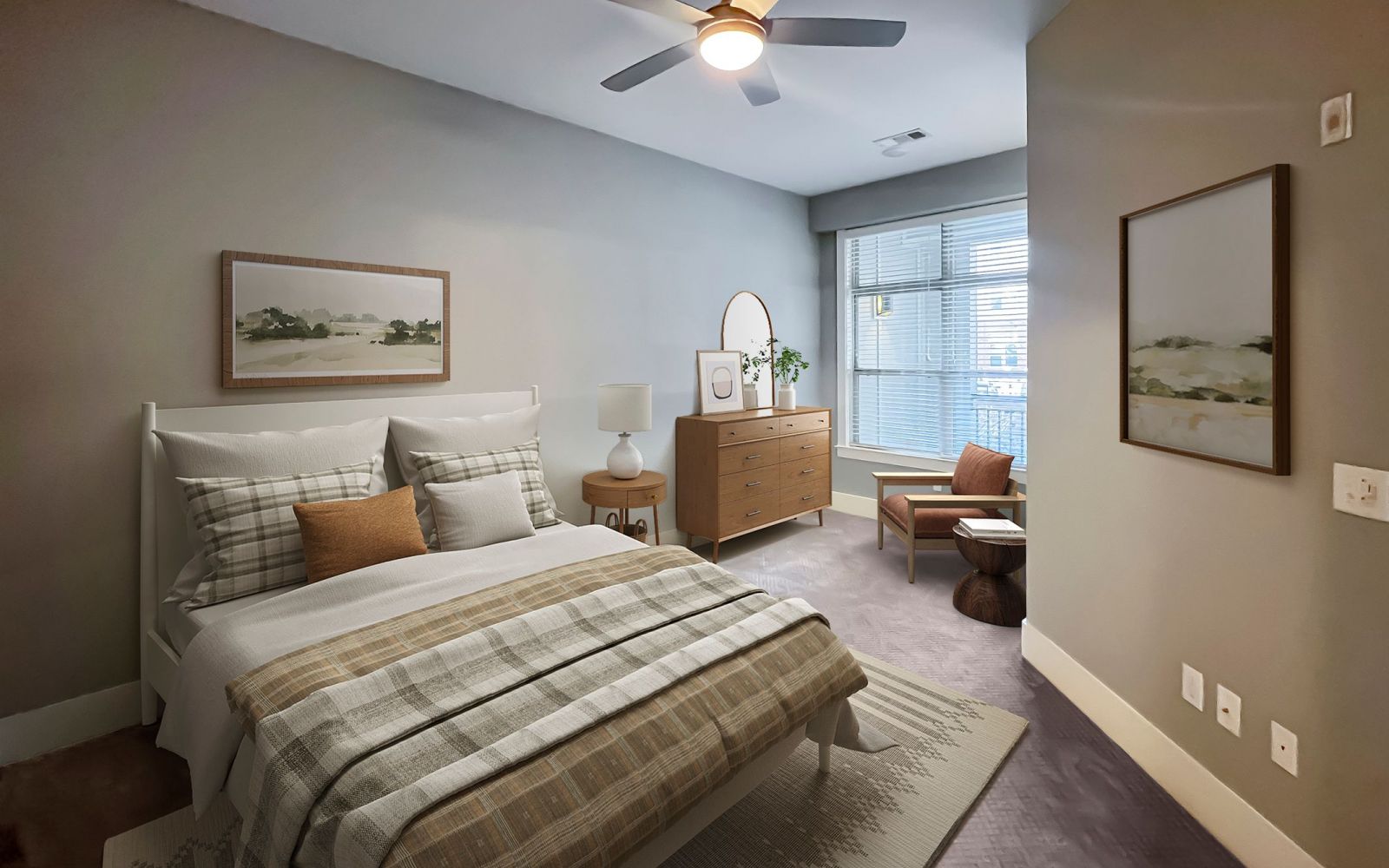 Apartments at Palladian Place in Durham, NC bedroom with large bed, dresser, ceiling fan, rug, chair, and large window