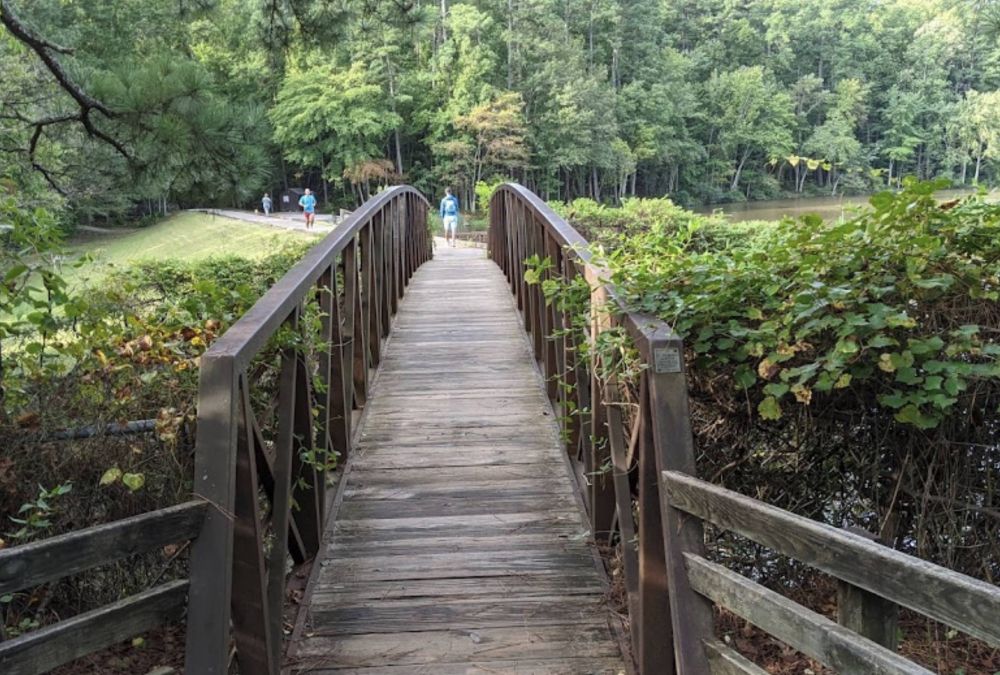 Apartments at Palladian Place in Durham, NC with nearby parks and walking paths with a footbridge and joggers