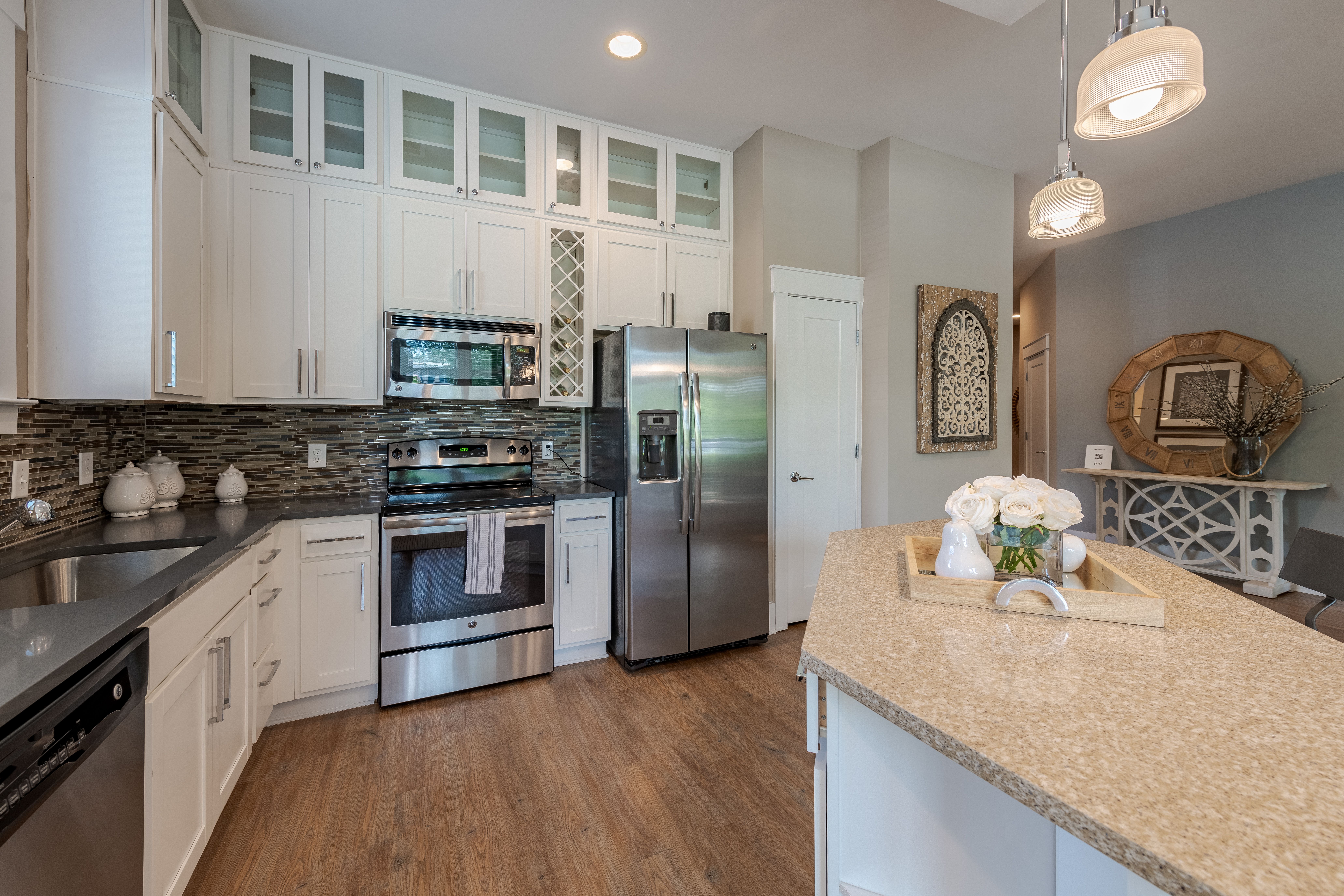 Apartments at Palladian Place bedroom with large bed and windows and natural light and living area with coffee table and kitchen in the background