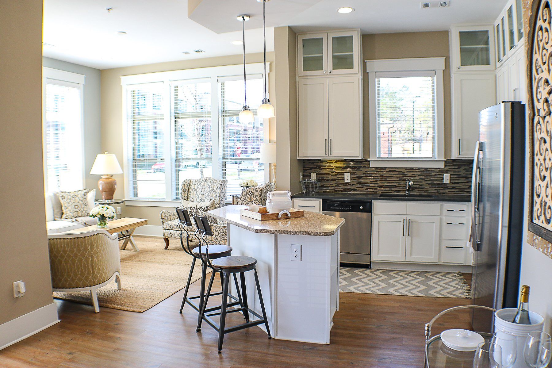 Apartments at Palladian Place in Durham, NC apartment interior kitchen with island, bar stools, plentiful storage space, and stainless steel appliances