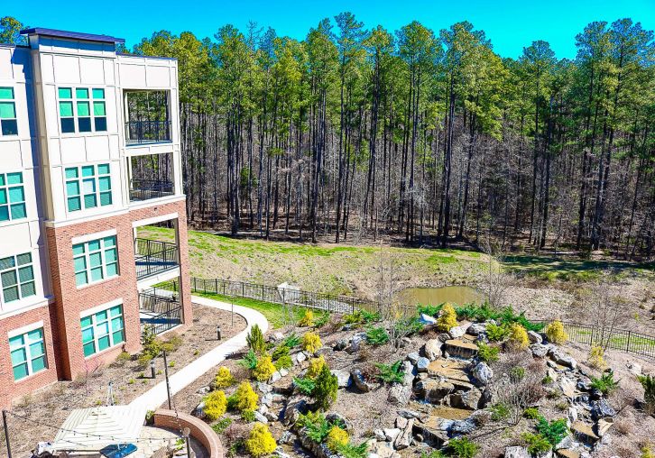 Apartments at Palladian Place in Durham, NC building exterior with a dense forest of mature trees in the background