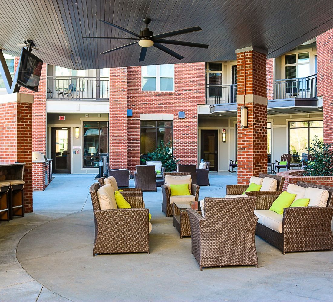 Apartments at Palladian Place with grill stations and lounge seating area, bar and bar stools, and a TV
