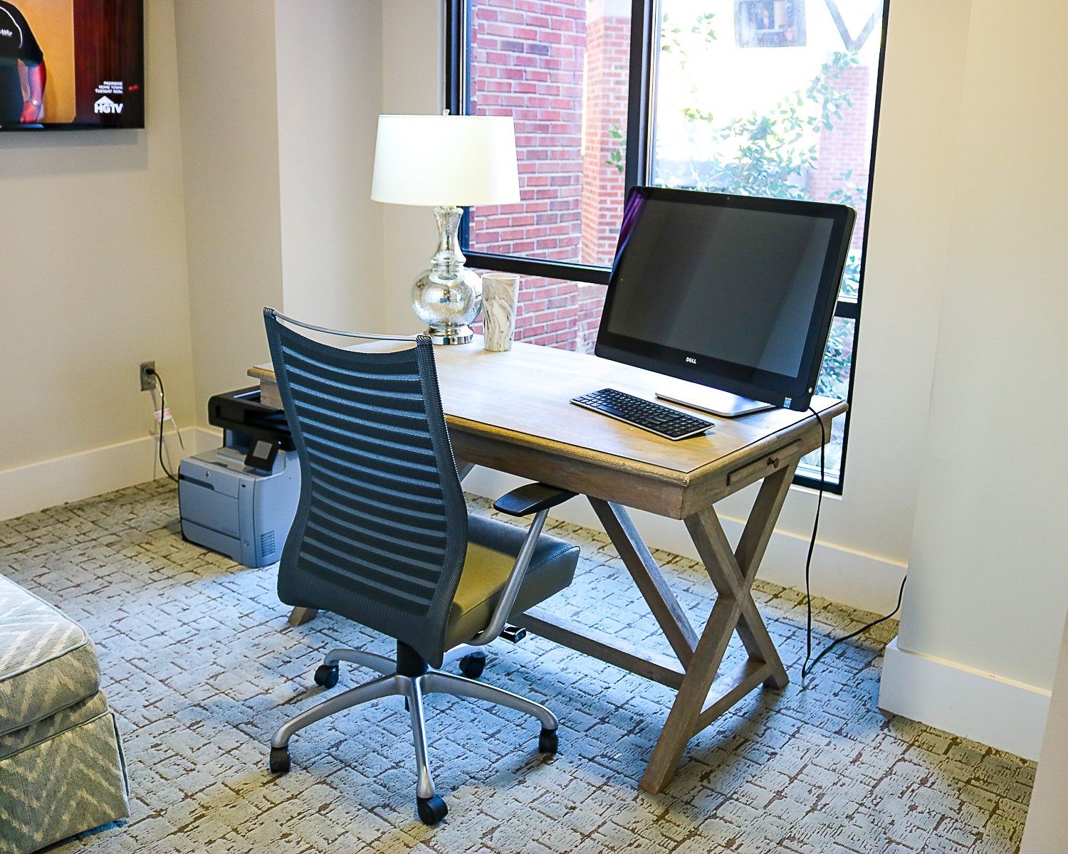 Apartments at Palladian Place with a business center, a desk, computer monitor, desk lamp, and comfy office chair
