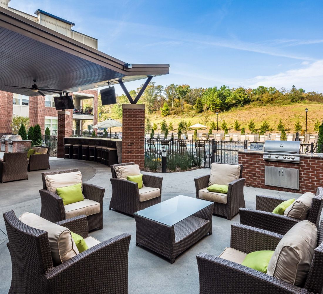 Apartments at Palladian Place with grill stations and lounge seating area, bar and bar stools, and a TV