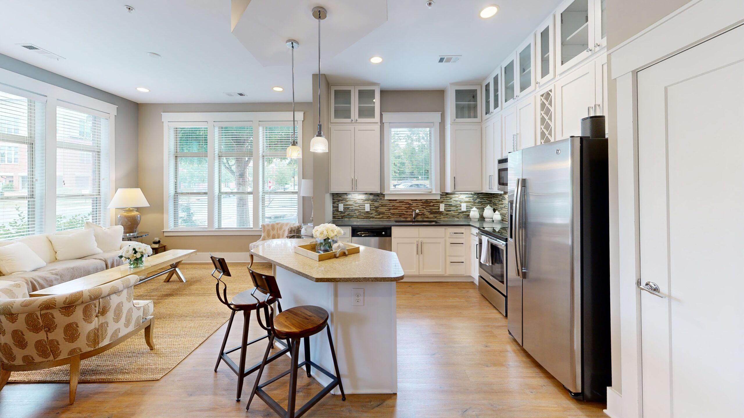 Apartments at Palladian Place bedroom with large bed and windows and natural light and living area with coffee table and kitchen in the background