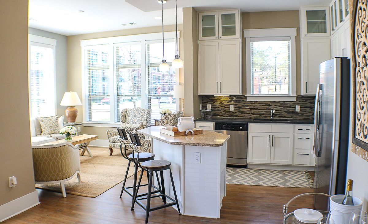 Apartments at Palladian Place in Durham, NC apartment interior kitchen with island, bar stools, plentiful storage space, and stainless steel appliances