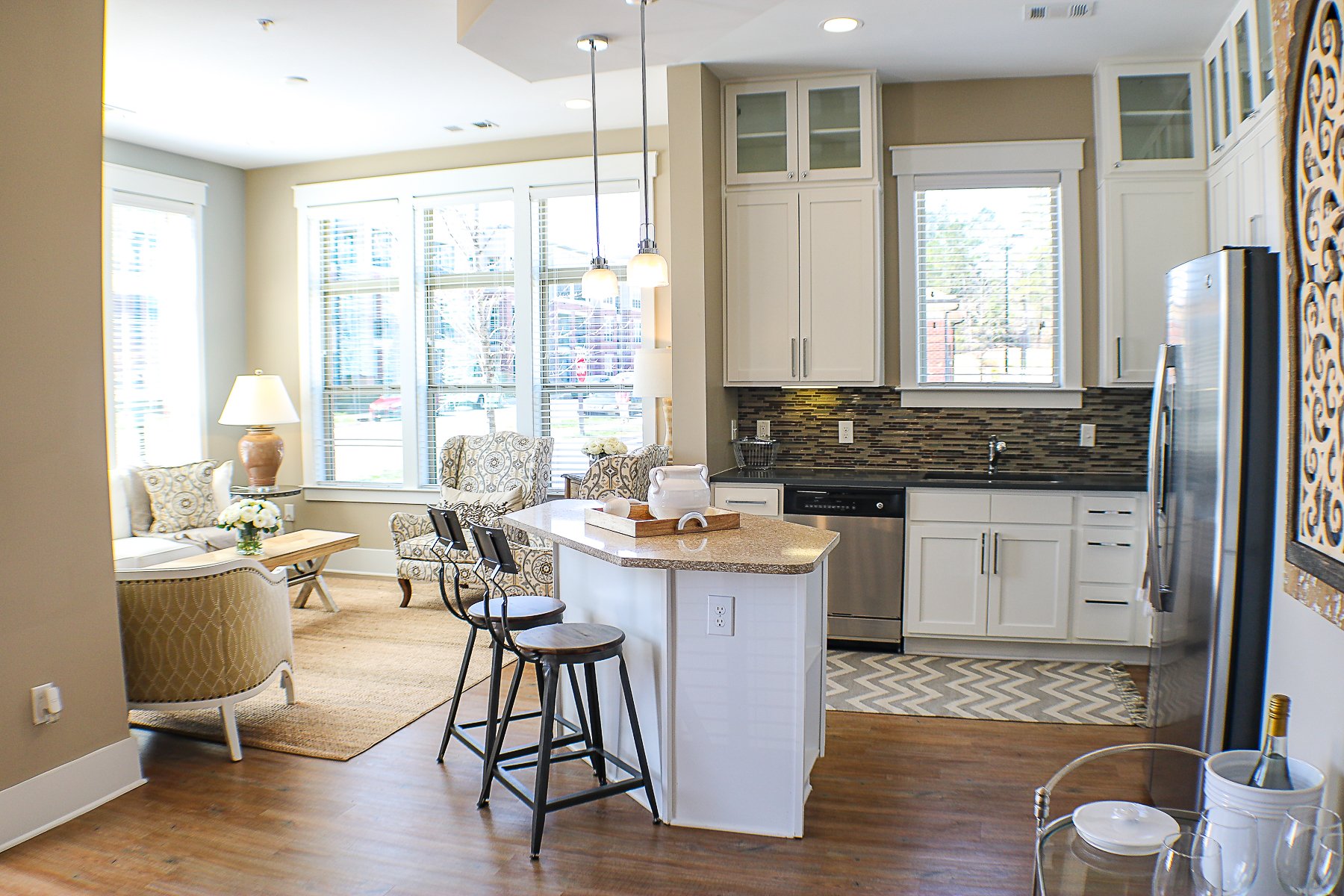 Apartments at Palladian Place in Durham, NC apartment interior kitchen with island, bar stools, plentiful storage space, and stainless steel appliances