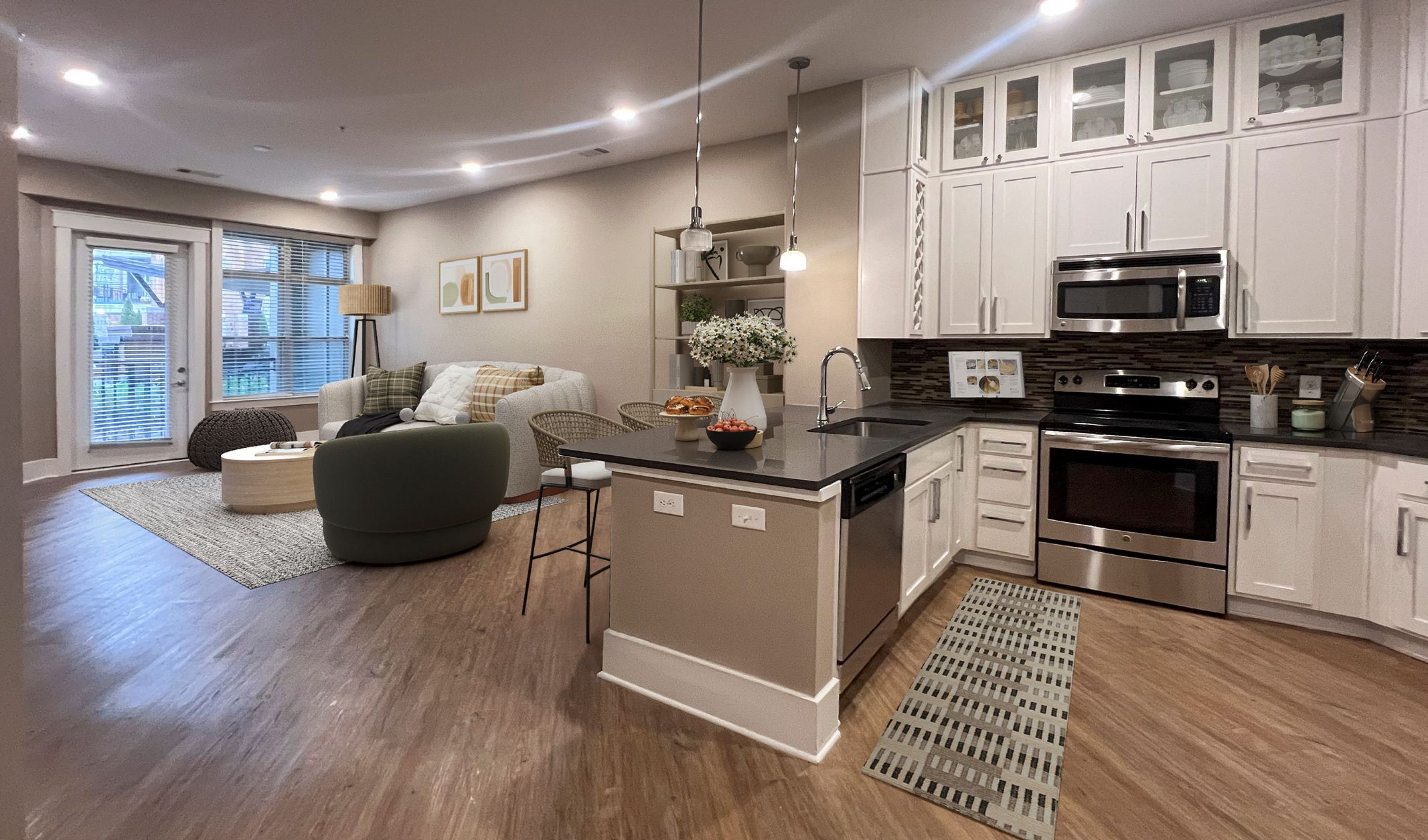 Apartments at Palladian Place in Durham, NC apartment interior kitchen with island, bar stools, plentiful storage space, and stainless steel appliances