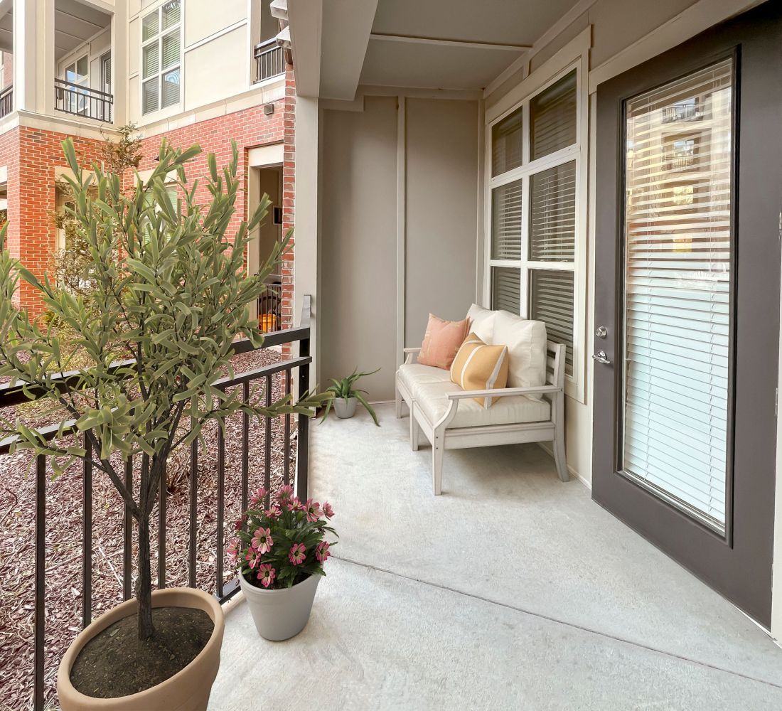 Apartments at Palladian Place in Durham, NC large covered patio with a love seat and plants