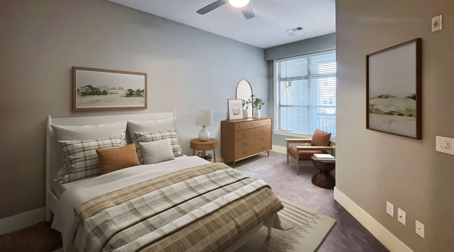 Apartments at Palladian Place in Durham, NC bedroom with large bed, dresser, ceiling fan, rug, chair, and large window