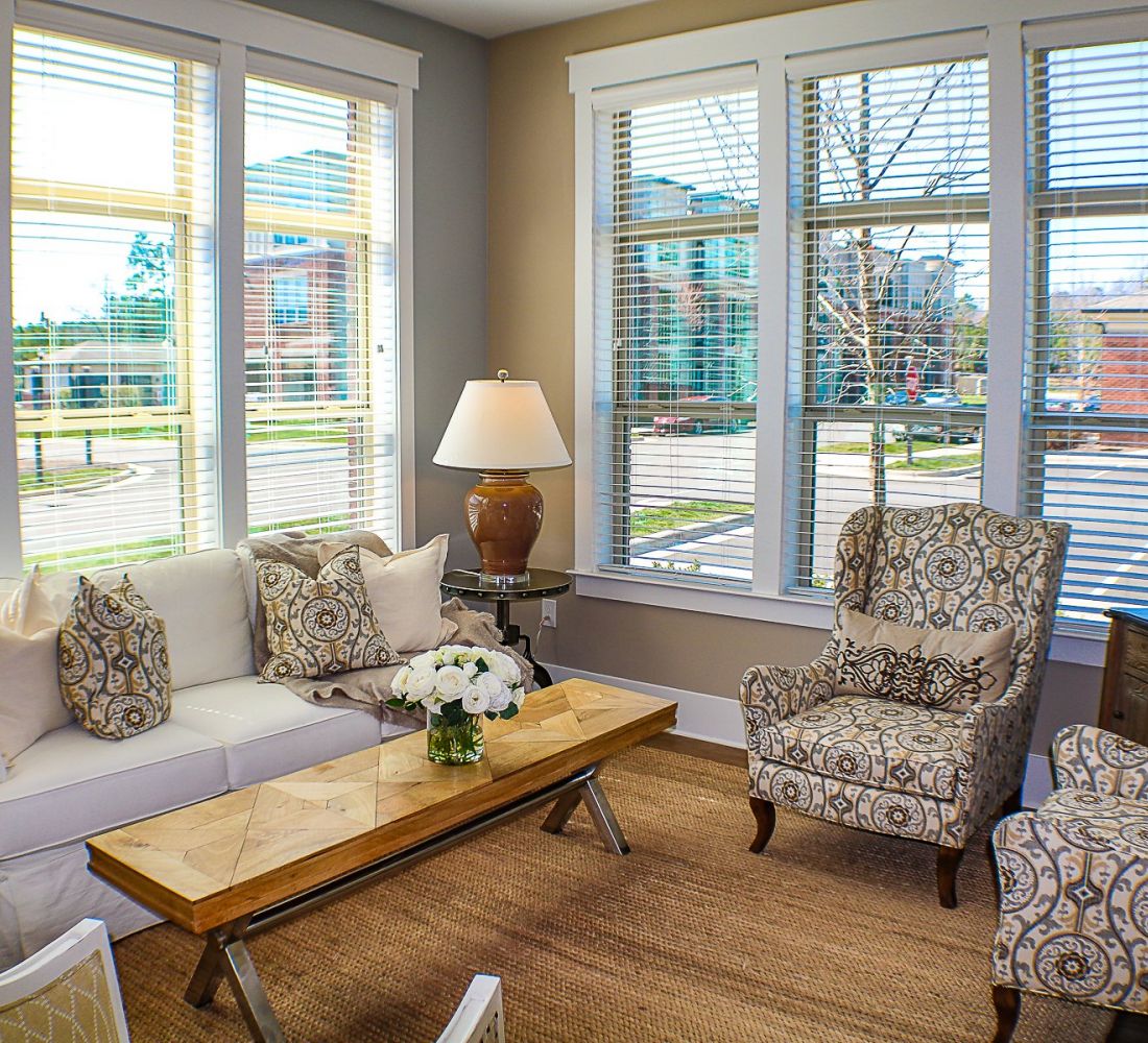 Apartments at Palladian Place in Durham, NC apartment interior living room with a couch, chairs, lamp, and a coffee table